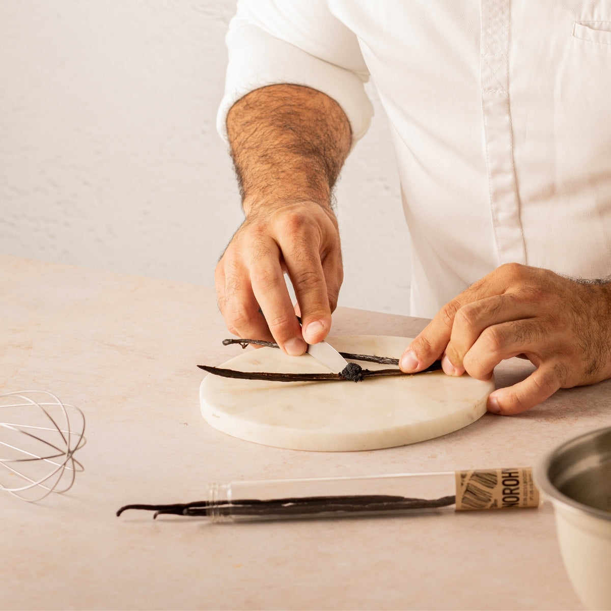 Chef pâtissier qui utilise une gousse de vanille 