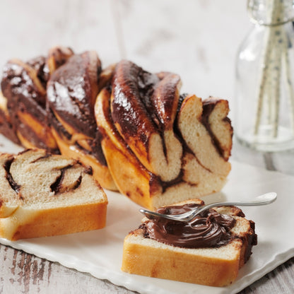 Babka coupé avec une tranche tartinée de pâte à tartiner aux noisettes 