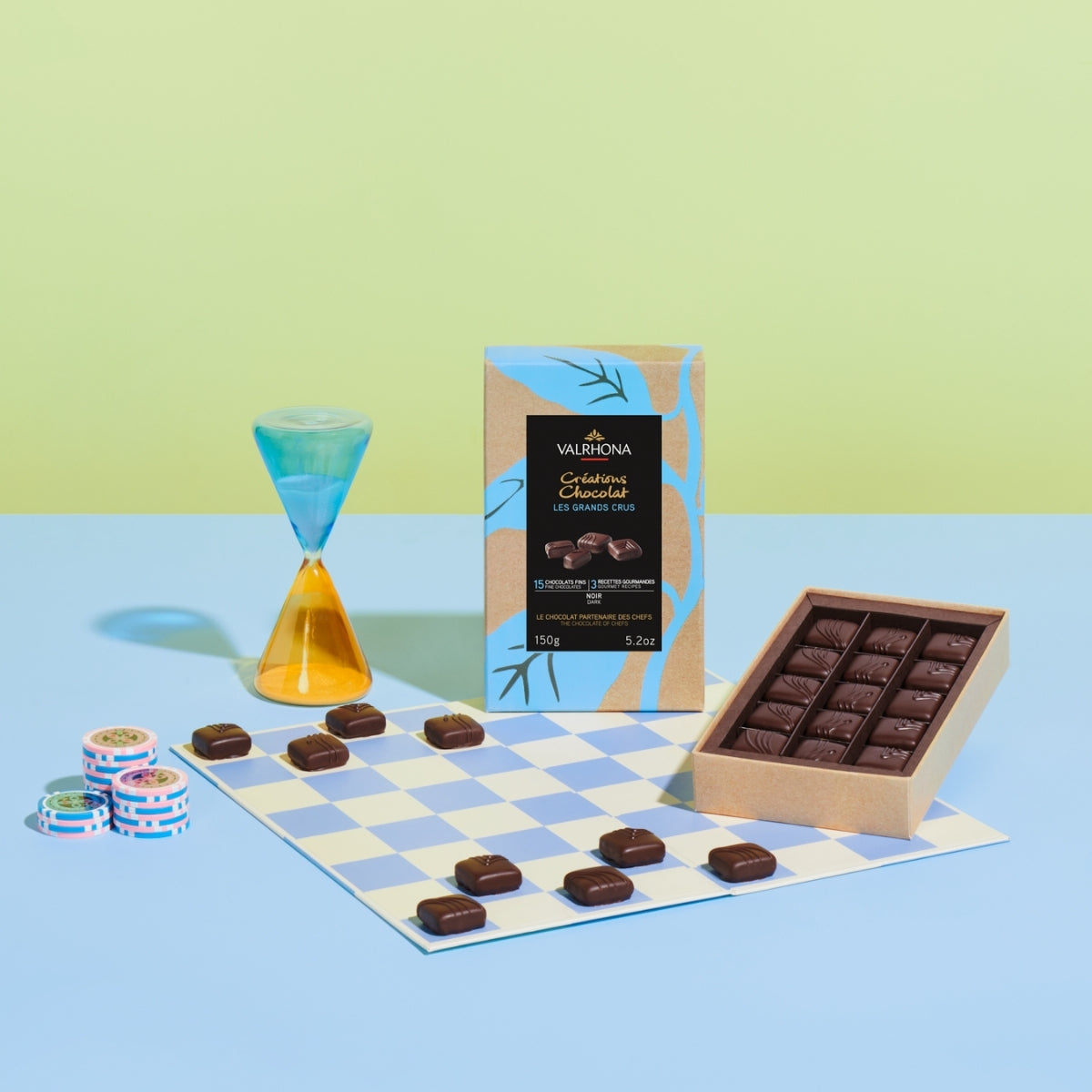 Coffret ouvert bonbons de chocolat noir posés sur une échiquier